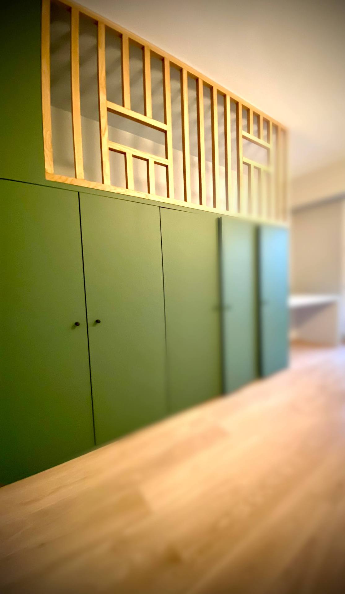 Meuble de rangement vert et claustra en bois