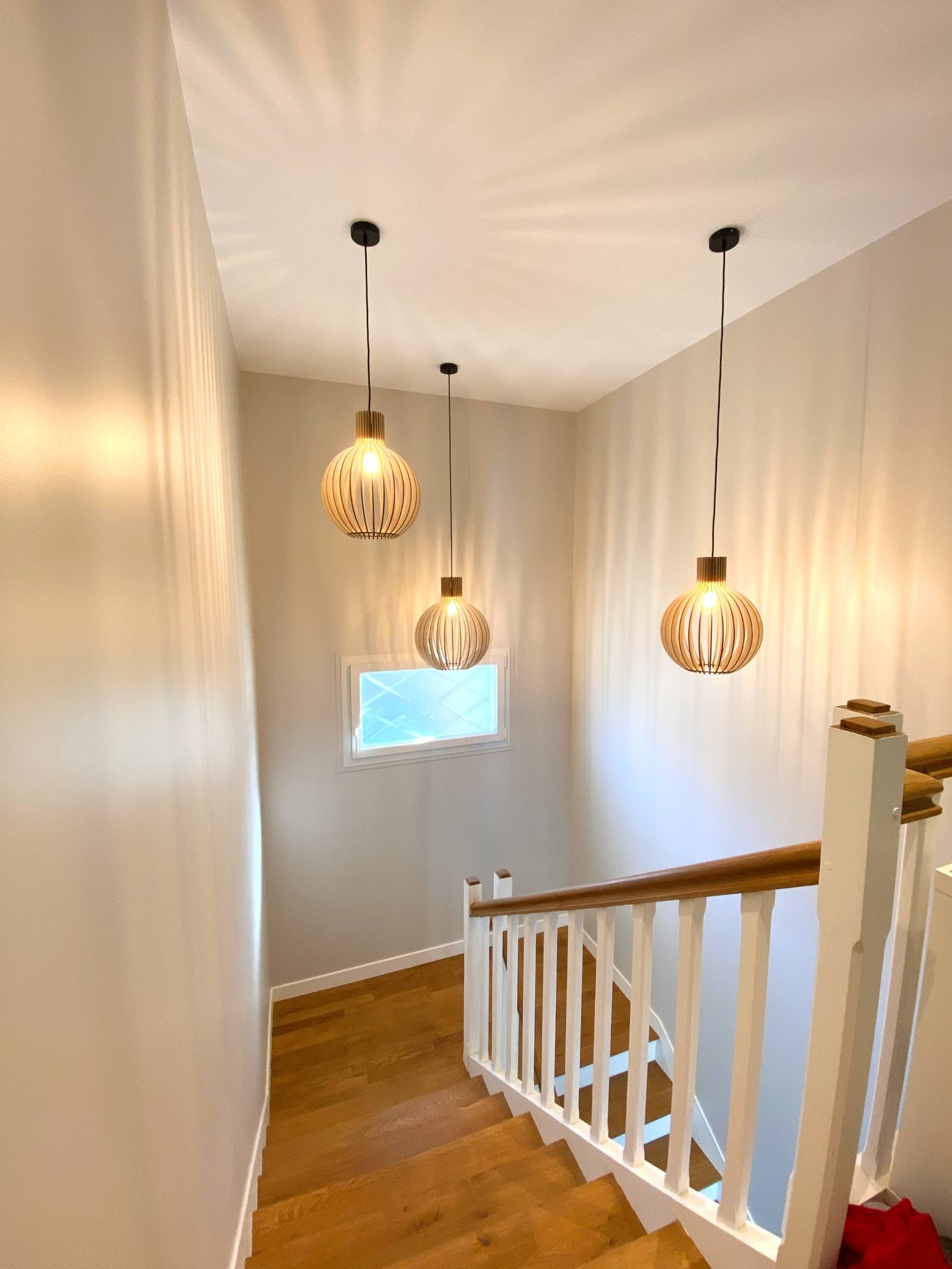 Cage d'escalier rythmée par des suspensions en bois